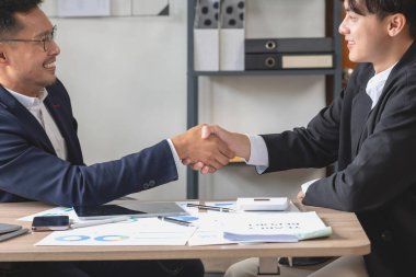 İki iş adamı iş birliği için tokalaşıyor.