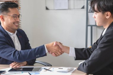 İki iş adamı iş birliği için tokalaşıyor.