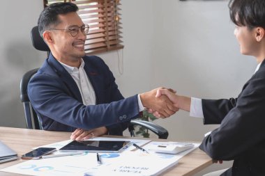 İki iş adamı iş birliği için tokalaşıyor.