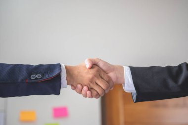 İki iş adamı iş birliği için tokalaşıyor.