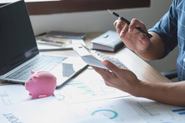 Ailenin geleceği için para biriktirmek için kumbaraya para atan bir adam..