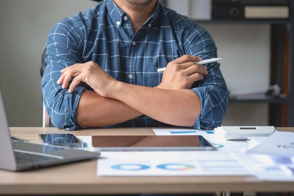 İş adamı, pazarlama stratejileri planlamak ve şirket için kârlı yatırımlar yapmak için hesap makineleri ve grafik analizi bilgisayar tabletleri kullanır.