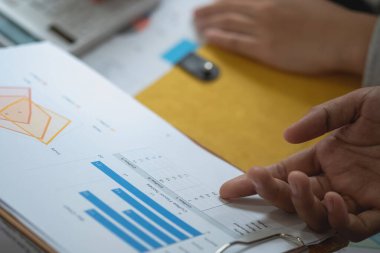 Pazarlama, Finans, Muhasebe, Planlama, bir grup iş adamı, kazançları için dizüstü bilgisayarları ve grafik çizelgeleriyle plan yapar ve şirketlerini hesaplamak için bir hesap makinesi kullanır..