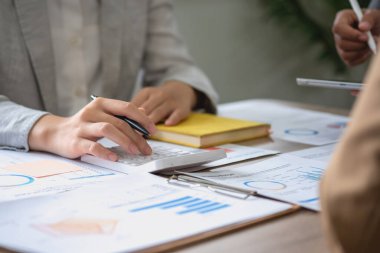 Pazarlama, Finans, Muhasebe, Planlama, bir grup iş adamı, kazançları için dizüstü bilgisayarları ve grafik çizelgeleriyle plan yapar ve şirketlerini hesaplamak için bir hesap makinesi kullanır..