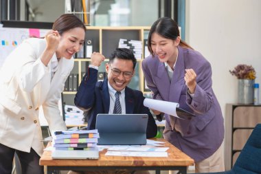 Takım işi üç gülümseyen ve mutlu Asyalı erkek ve kadın takımı tablet ve dizüstü bilgisayarları kullanarak şirket içindeki bir şirket çizelgesinde istatistikler oluşturuyorlar. Meslektaşlar konsepti.