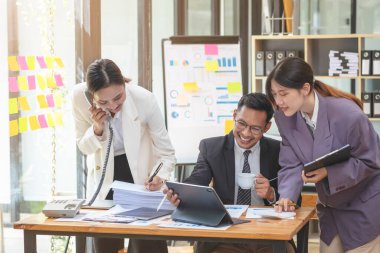 Şirket için beyin fırtınası fikirlerine yardım eden Asyalı işadamları ekibi, şirketin ticari başarı elde etmesinden duydukları neşe ve mutluluğu dile getiriyorlar..