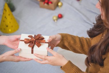 Mutlu Noeller ve mutlu tatiller! Sarı gömlekli güzel yüzlü genç bir kadın Noel ağacı süslenmiş bir evde hediye kutularıyla neşe gösteriyor. Xmas 'tan Önce Portre