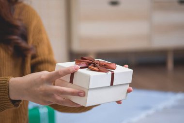 Mutlu Noeller ve mutlu tatiller! Sarı gömlekli güzel yüzlü genç bir kadın Noel ağacı süslenmiş bir evde hediye kutularıyla neşe gösteriyor. Xmas 'tan Önce Portre