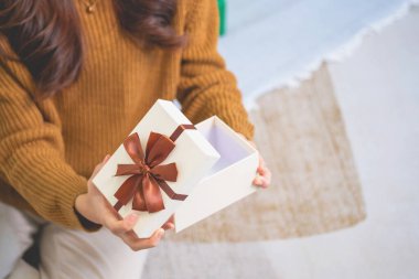 Mutlu Noeller ve mutlu tatiller! Sarı gömlekli güzel yüzlü genç bir kadın Noel ağacı süslenmiş bir evde hediye kutularıyla neşe gösteriyor. Xmas 'tan Önce Portre