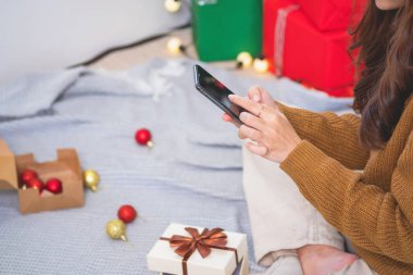 Mutlu Noeller ve mutlu tatiller! Sarı gömlekli güzel yüzlü genç bir kadın Noel ağacı süslenmiş bir evde hediye kutularıyla neşe gösteriyor. Xmas 'tan Önce Portre