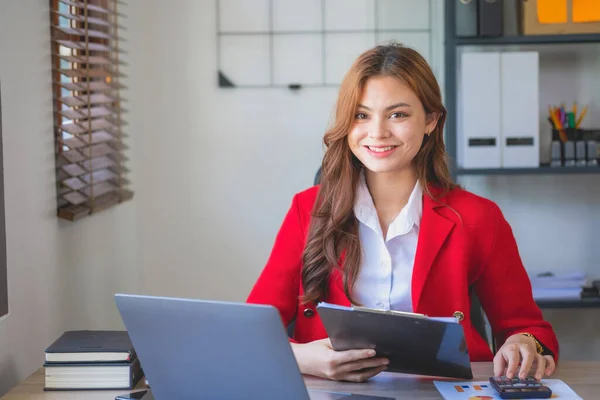 stock image Marketing, Financial, Accounting, Planning, business women analyze company results and profits with graph statistics. Use a laptop computer and a calculator to calculate the company is balance.