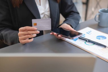 Genç Asyalı kadın internetten kredi kartıyla alışveriş yapıyor. ev kredi kartı ödeme konsepti dahilinde çevrimiçi ödeme için
