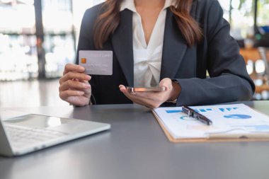 Genç Asyalı kadın internetten kredi kartıyla alışveriş yapıyor. ev kredi kartı ödeme konsepti dahilinde çevrimiçi ödeme için