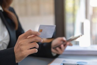 Genç Asyalı kadın internetten kredi kartıyla alışveriş yapıyor. ev kredi kartı ödeme konsepti dahilinde çevrimiçi ödeme için