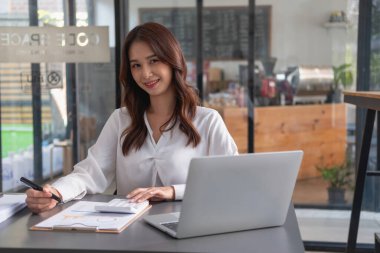 Pazarlama, Finansal, Muhasebe, Planlama, İş kadınları şirket sonuçlarını ve karlarını grafik istatistikleriyle analiz eder. Şirketi hesaplamak için dizüstü bilgisayar ve hesap makinesi kullanın..
