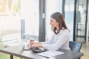 Pazarlama, Finansal, Muhasebe, Planlama, İş kadınları şirket sonuçlarını ve karlarını grafik istatistikleriyle analiz eder. Şirketi hesaplamak için dizüstü bilgisayar ve hesap makinesi kullanın..