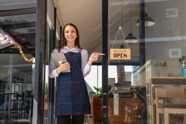 Portrait of a woman, a coffee shop business owner smiling beautifully and opening a coffee shop that is her own business, Small business concept.	