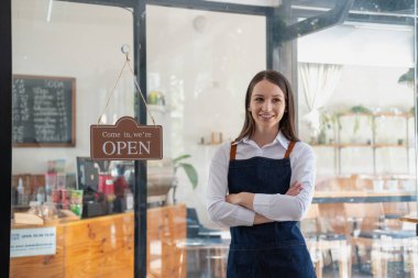 Portrait of a woman, a coffee shop business owner smiling beautifully and opening a coffee shop that is her own business, Small business concept.	