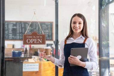 Portrait of a woman, a coffee shop business owner smiling beautifully and opening a coffee shop that is her own business, Small business concept.	