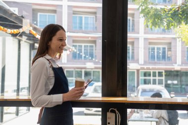 Portrait of a woman, a coffee shop business owner smiling beautifully and opening a coffee shop that is her own business, Small business concept.	