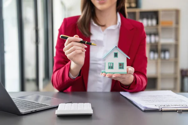 stock image Accountant, businessman, real estate agent, Businessman handing model house to customers along with house interest calculation documents for customers to sign.