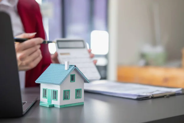 stock image Accountant, businessman, real estate agent, Businessman handing model house to customers along with house interest calculation documents for customers to sign.