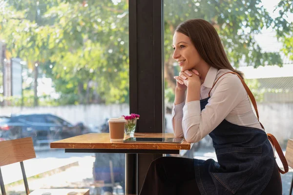 Portrait of a woman, a coffee shop business owner smiling beautifully and opening a coffee shop that is her own business, Small business concept.