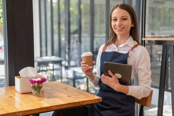 Portrait of a woman, a coffee shop business owner smiling beautifully and opening a coffee shop that is her own business, Small business concept.