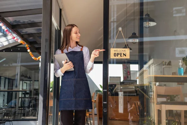 Portrait of a woman, a coffee shop business owner smiling beautifully and opening a coffee shop that is her own business, Small business concept.	