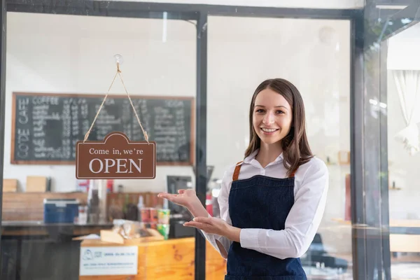 Portrait of a woman, a coffee shop business owner smiling beautifully and opening a coffee shop that is her own business, Small business concept.	