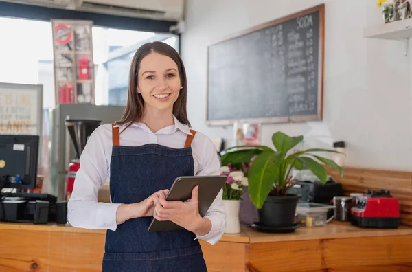 Portrait of a woman, a coffee shop business owner smiling beautifully and opening a coffee shop that is her own business, Small business concept.	