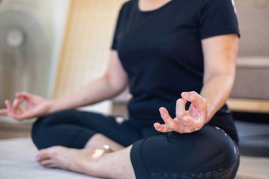 Asyalı yaşlı bir kadın iyi sağlık için yoga yaparken yaşlı bir kadın, rahatlatıcı bir günde evde vücudunun sağlığıyla ilgilenir. iyi sağlık kavramı