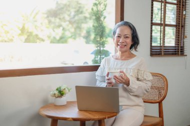Yaşlı kadınlar oturur ve rahatlar, stresli, dizüstü bilgisayarlarda dizileri izlerler, kitap okurlar ve notlar alırlar ve evde en parlak ışık ve temiz havayla mutlu bir şekilde çaylarını yudumlarlar.. 