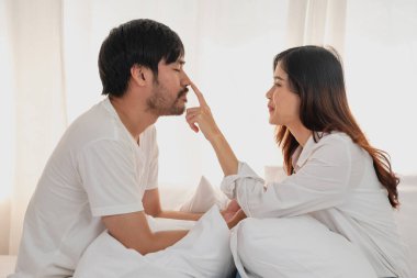 Mutlu Asyalı genç çift kucaklaşıyorlar, takılıyorlar, evde neşeyle yatakta oynuyorlar, aile bağlarını geliştirmek için romantik zaman. aile kavramı.