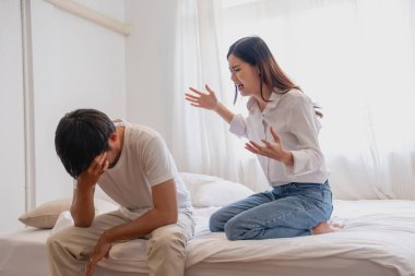 İç şiddet. Aile içi anlaşmazlık bir kadın kocasını öfkeyle azarlıyor. Kocayı kötü hissettir. Evin içindeki yatakta, aile kavgası konsepti..