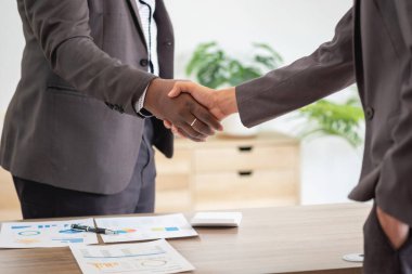 Tatmin olmuş siyah müvekkil, başarılı iş görüşmelerinden sonra Afrikalı Amerikalı iş adamlarının el sıkışması için müdüre teşekkür ediyor. Kiralıyorum. Satın alma hizmetleri.