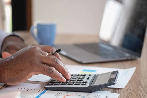 stock image African black businessman sitting doing a financial report and studying annual profit analysis An accountant checking the financial status of the company is in the office.