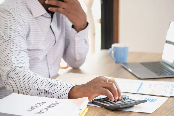 Stock image African black businessman sitting doing a financial report and studying annual profit analysis An accountant checking the financial status of the company is in the office.