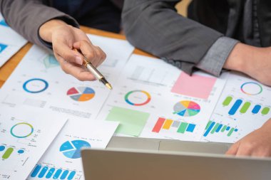 Asyalı iş adamları pazarlama personelinden oluşur. Muhasebeci ve finans görevlisi tabletleri kullanarak şirket kârlarını analiz etmede birbirlerine yardımcı oluyorlar. Hesap makinesi, dizüstü bilgisayar, grafik kağıdı ve şirket kalemleri..