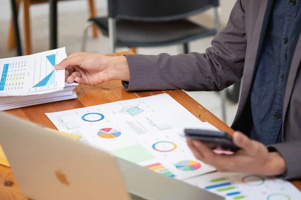 stock image Asian business team consists of marketing staff. accountant and financial officer Help each other analyze company profits using tablets. calculator Laptop computers, graph paper, and corporate pens.