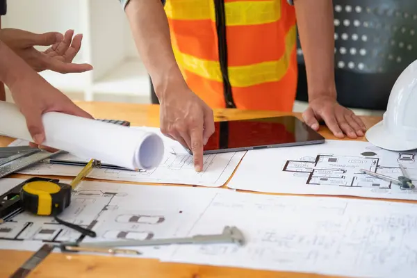 stock image Asian engineers brainstorm and measure to document cost estimates and write floor plans for architectural and engineering designs for houses and buildings.