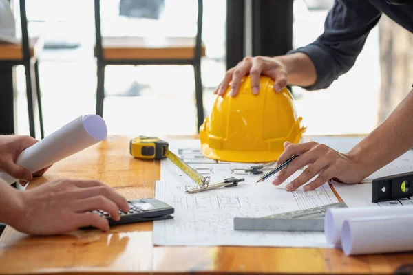 stock image Asian engineers brainstorm and measure to document cost estimates and write floor plans for architectural and engineering designs for houses and buildings.