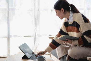 Asyalı kız öğrenciler çevrimiçi çalışıyor, evde kalıyor, öğretmenlik yapıyor, video çekiyor ve internette yakınlaştırıyor. İnternette bilgisayar, tablet ve cep telefonuyla İngilizce öğrenen mutlu Asyalı kız. çevrimiçi öğrenme kavramı.