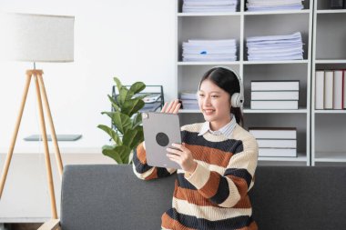Asyalı kız öğrenciler çevrimiçi çalışıyor, evde kalıyor, öğretmenlik yapıyor, video çekiyor ve internette yakınlaştırıyor. İnternette bilgisayar, tablet ve cep telefonuyla İngilizce öğrenen mutlu Asyalı kız. çevrimiçi öğrenme kavramı.