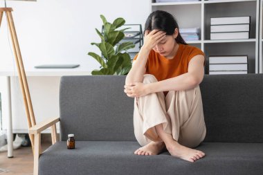 Kanepede çok sayıda hapla oturan genç kadın depresyondaki kadın aşırı doz uyuşturucu ve depresyon konseptiyle kendini öldürmek istiyor.