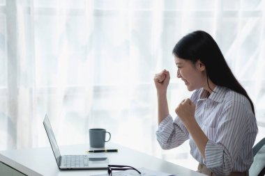 Bilgisayar masasına uygun gülümseyen Asyalı bir iş kadınının portresi. Küçük işletme KOBİ çevrimiçi serbest pazarlama girişimi iş başarısı jesti yapıyor.