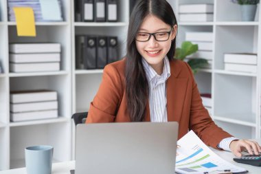 Ofiste çalışan iş kadını mali raporları hesaplamak için hesap makinesi kullanıyor. Bilgisayarlı satış verileri ve ofis masasında iş belgeleri. Kapatın. İş finans ve yatırım.