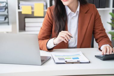 Ofiste çalışan iş kadını mali raporları hesaplamak için hesap makinesi kullanıyor. Bilgisayarlı satış verileri ve ofis masasında iş belgeleri. Kapatın. İş finans ve yatırım.
