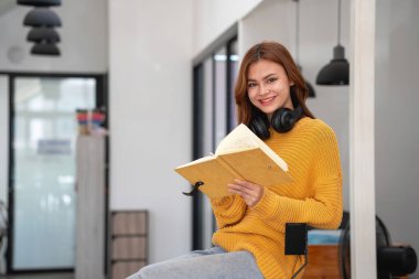 Mutlu Latin kız kolej öğrencisi uzaktan öğrenim kursu, uzak üniversite web sitesi ya da laptop üzerinden konuşma videosu alıyor ve evdeki ya da kampüsteki sanal toplantı seminerinde not defteri kullanıyor.