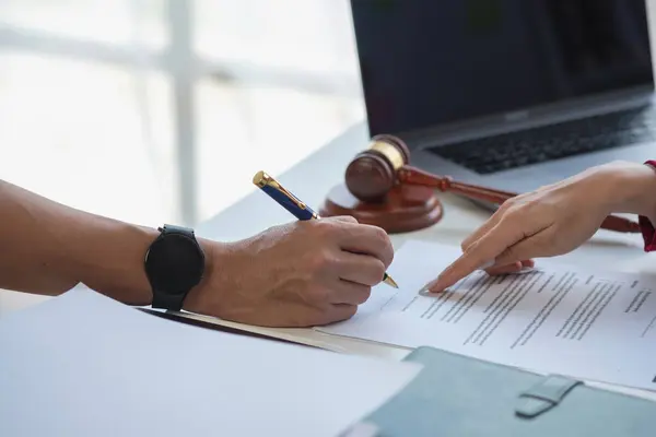 Asyalı kadın avukat ya da hukuk danışmanı bir sözleşme imzalarken avukatlık bürosundaki müvekkil ile olan sözleşme, müvekkili yasal danışman olarak yönlendirecek..